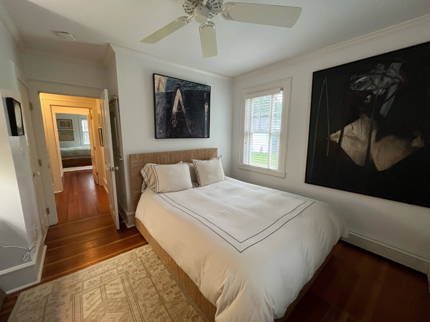43 Cottage Street Edgartown, MA 02539 - Photo 17 of 24 a bedroom with a large bed and a chandelier