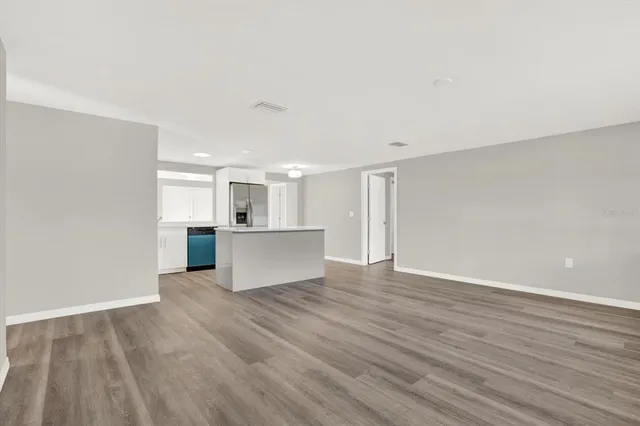 a view of a kitchen with wooden floor and windows