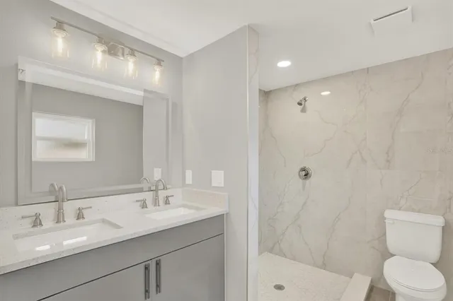 a bathroom with a sink a toilet and shower