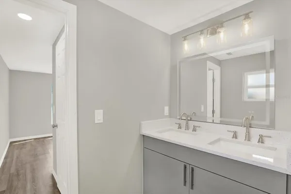 a bathroom with a double vanity sink and a mirror
