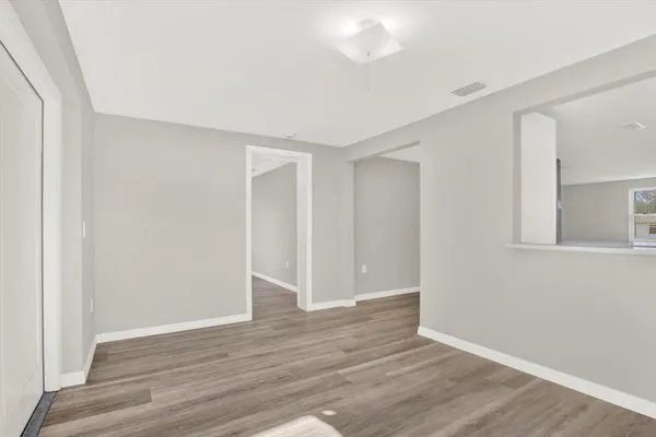 a view of an empty room with wooden floor
