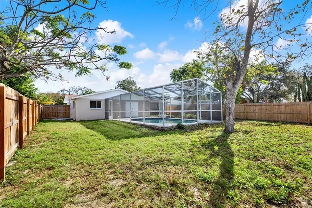 a view of a house with a big yard and large trees