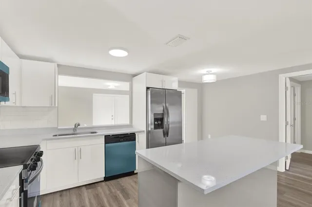 a kitchen with a sink cabinets and stainless steel appliances