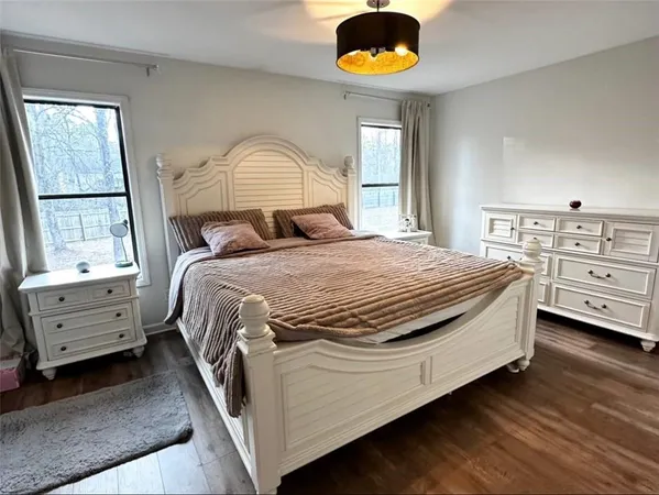 a bedroom with a bed a flat screen tv and a chandelier