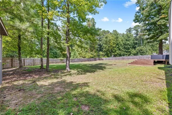 a view of a house with a big yard and large trees