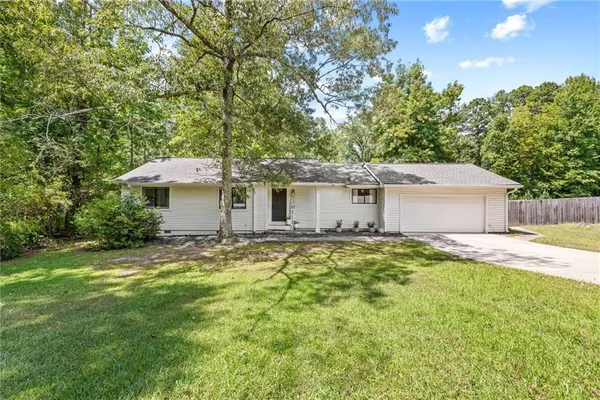 a view of a house with a backyard and a tree