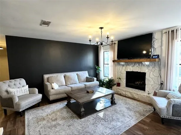 a dining room with furniture a chandelier and wooden floor