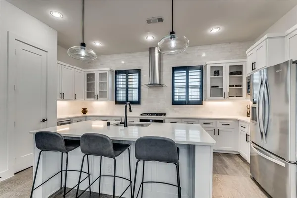 a kitchen with stainless steel appliances a sink stove and refrigerator