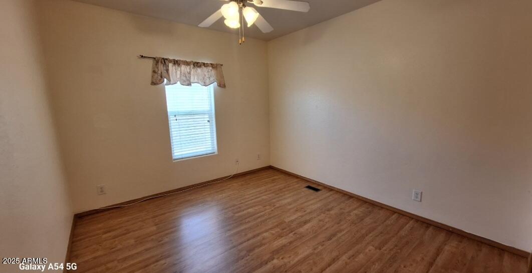 9351 East 28th Street East, Unit 212 Yuma, AZ 85365 - Photo 38 of 54 an empty room with wooden floor chandelier fan and windows