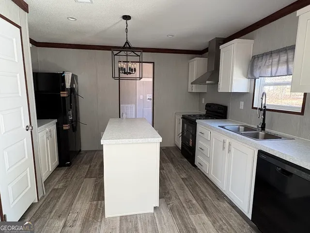 a kitchen with a sink a refrigerator and cabinets