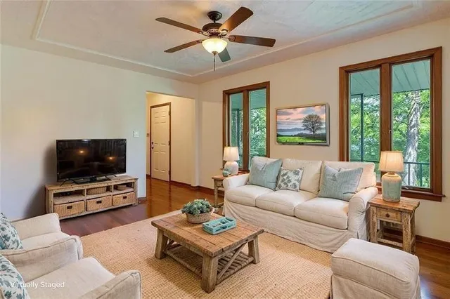 a living room with furniture a flat screen tv and a floor to ceiling window