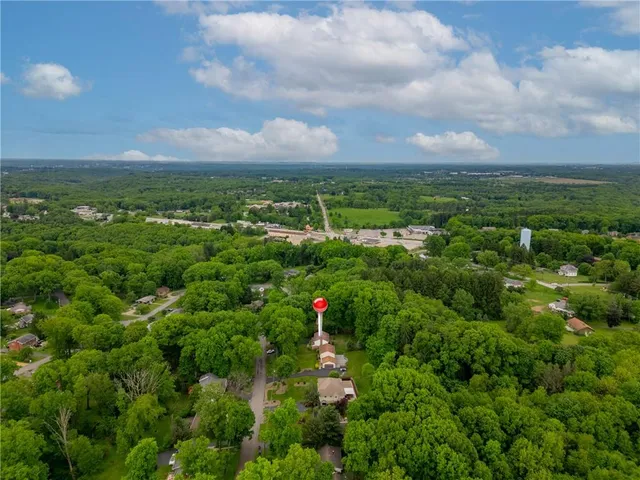 an aerial view of residential houses with outdoor space and trees