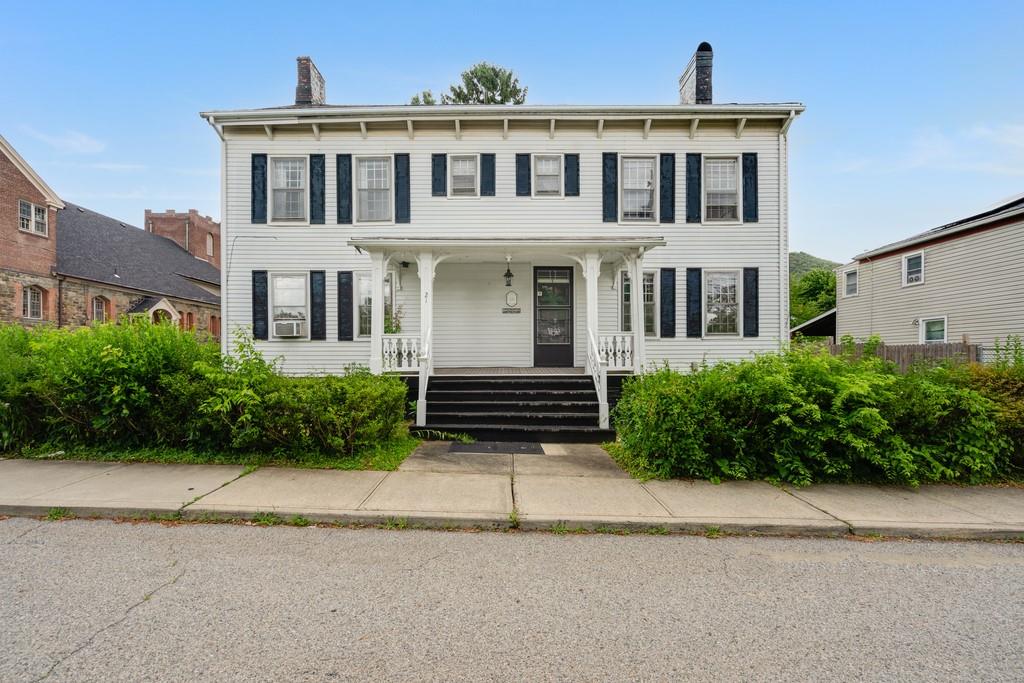 a house that has a lot of plants in front of it