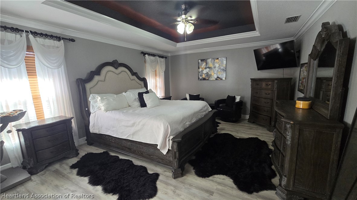 808 Spring Lake Boulevard Sebring, FL 33876 - Photo 11 of 38 a bedroom with a bed a fireplace and a flat tv screen