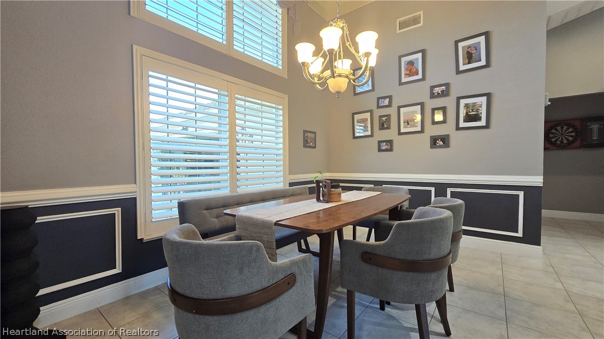 808 Spring Lake Boulevard Sebring, FL 33876 - Photo 18 of 38 a view of a dining room with furniture a chandelier and a window