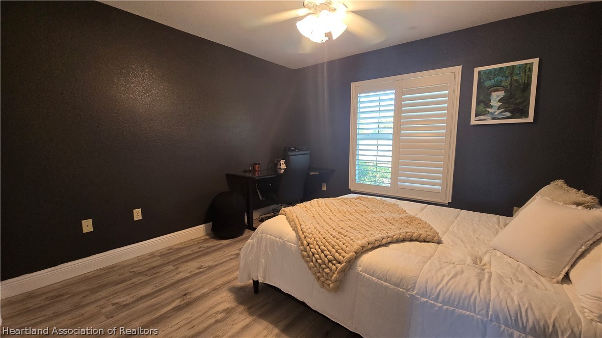 808 Spring Lake Boulevard Sebring, FL 33876 - Photo 22 of 38 a bedroom with a bed and a chandelier