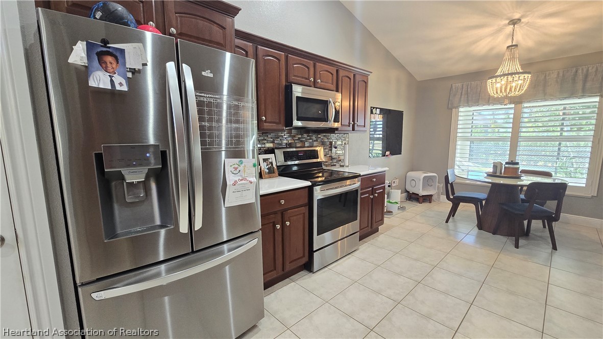 808 Spring Lake Boulevard Sebring, FL 33876 - Photo 10 of 38 a kitchen with stainless steel appliances granite countertop a refrigerator stove and sink