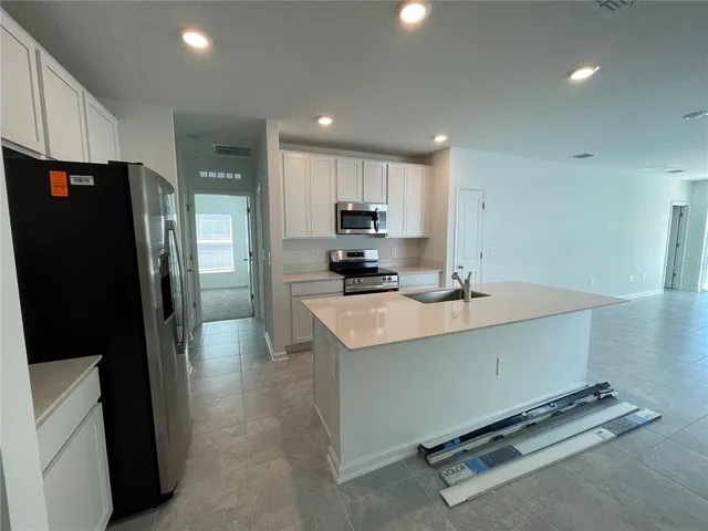 a kitchen with stainless steel appliances a refrigerator and a stove top oven
