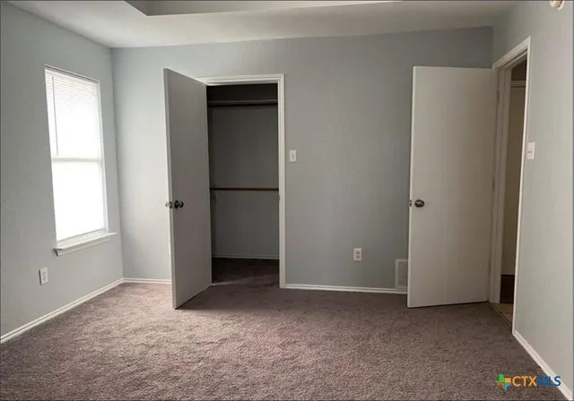 an empty room with windows and closet