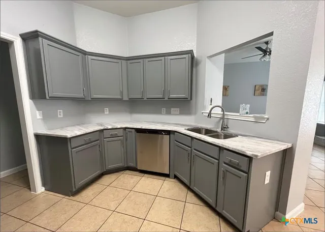 a kitchen with a sink dishwasher and cabinets