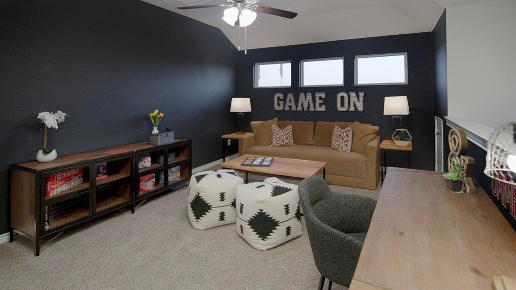 500 Range Road Caddo Mills, TX 75135 - Photo 23 of 35 Carpeted room featuring a ceiling fan, dark accent wall, and three upper transom windows