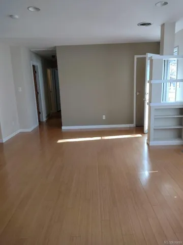 a view of an empty room with wooden floor