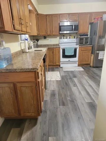 a kitchen with stainless steel appliances granite countertop a stove a sink dishwasher and a refrigerator