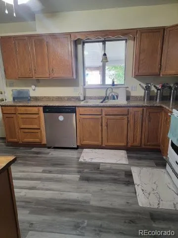 a kitchen with granite countertop a sink window and cabinets
