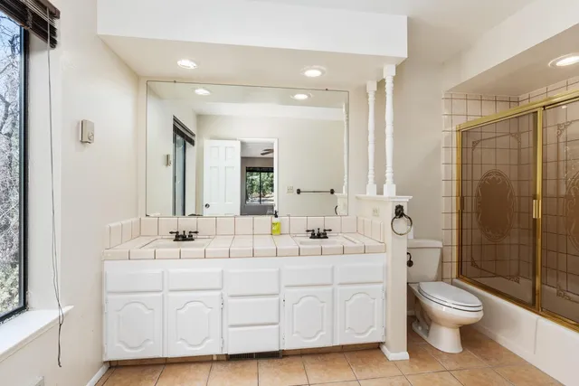 a bathroom with a double vanity sink toilet and shower