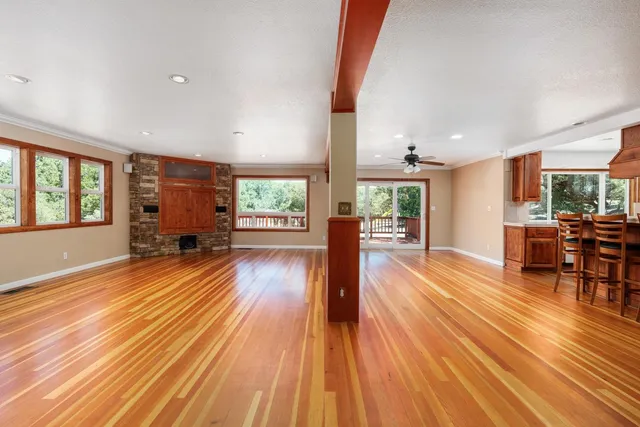 a living room with furniture wooden floor and large windows