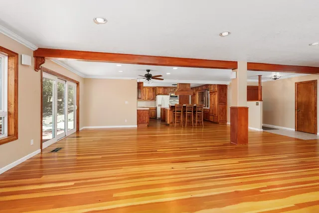 an empty room with wooden floor and furniture