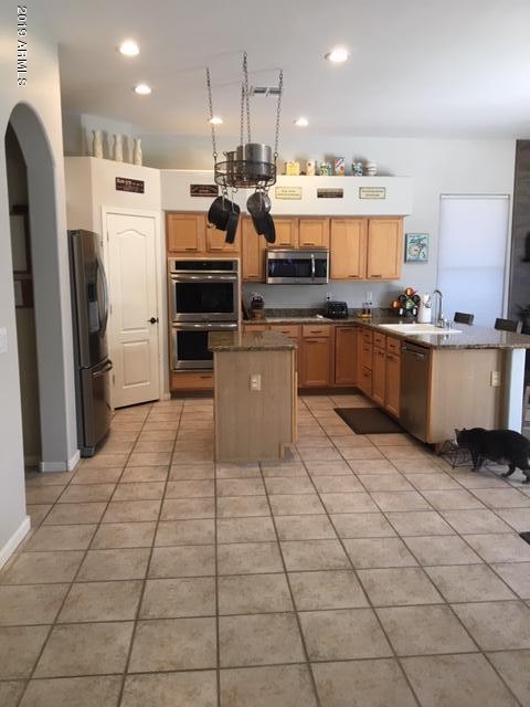 3443 East Rosa Lane Gilbert, AZ 85297 - Photo 14 of 53 a kitchen with stainless steel appliances granite countertop a refrigerator and a stove top oven