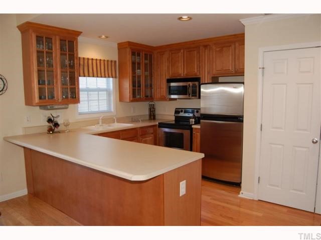 2031 Rivergate Road, Unit 107 Raleigh, NC 27614 - Photo 7 of 12 a kitchen with kitchen island a sink refrigerator stove and microwave