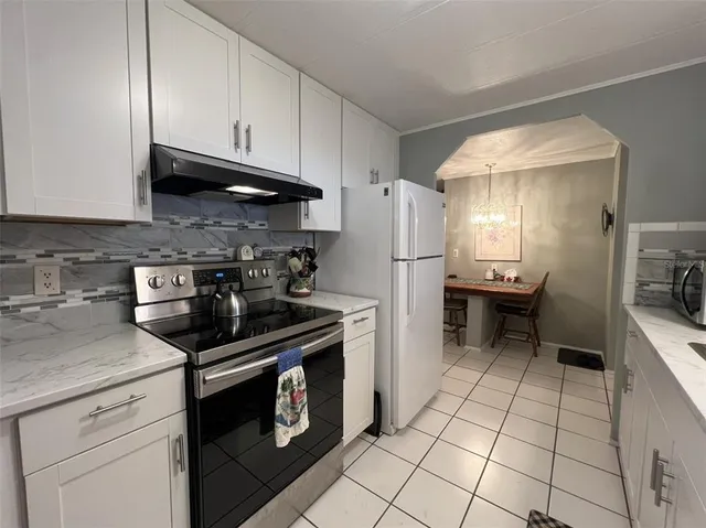 a kitchen with stainless steel appliances granite countertop a stove a refrigerator and a sink