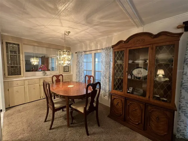 a view of a dining room with furniture and chandelier