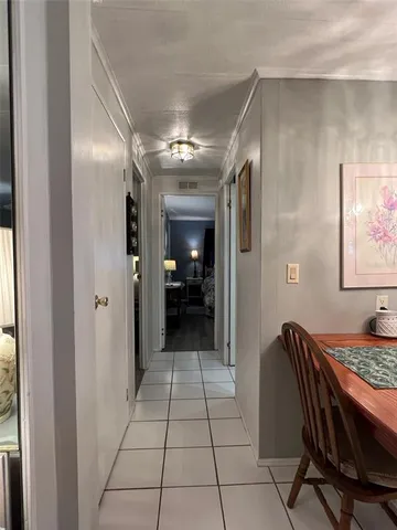 a view of a hallway to a livingroom with furniture