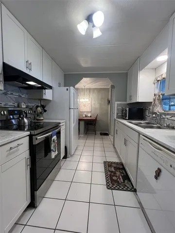 a kitchen with a stove a sink and a refrigerator