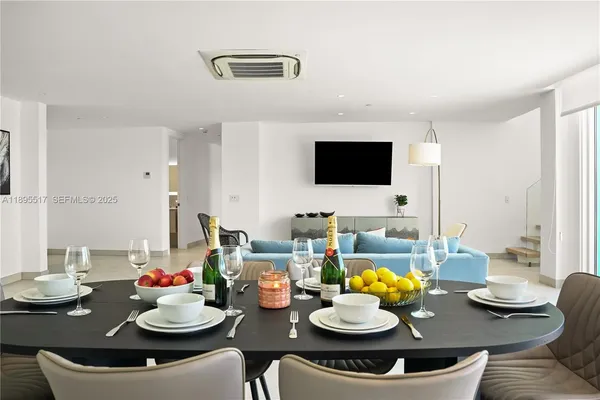 a view of a dining room with furniture and a flat screen tv