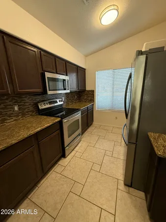 a kitchen with stainless steel appliances a refrigerator sink and microwave