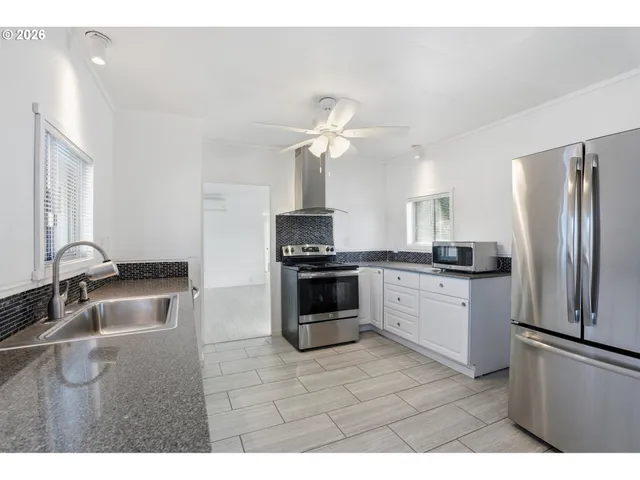 a kitchen with a refrigerator sink and cabinets