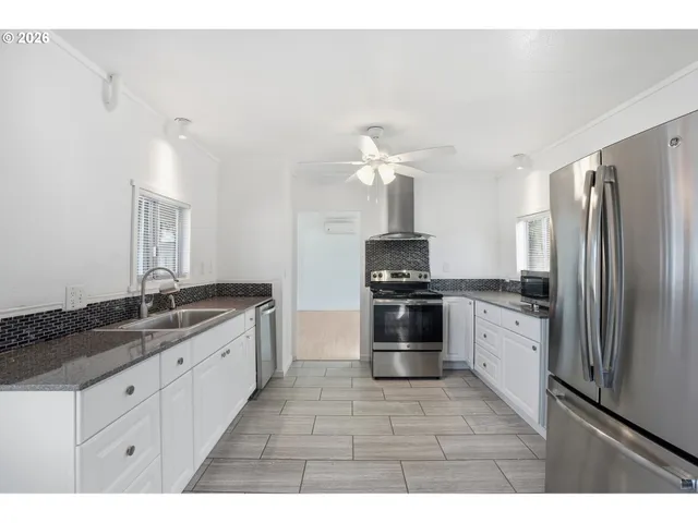 a kitchen with granite countertop a refrigerator and a sink