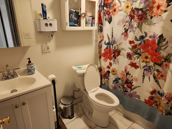 a white toilet sitting next to a bathroom sink and vanity