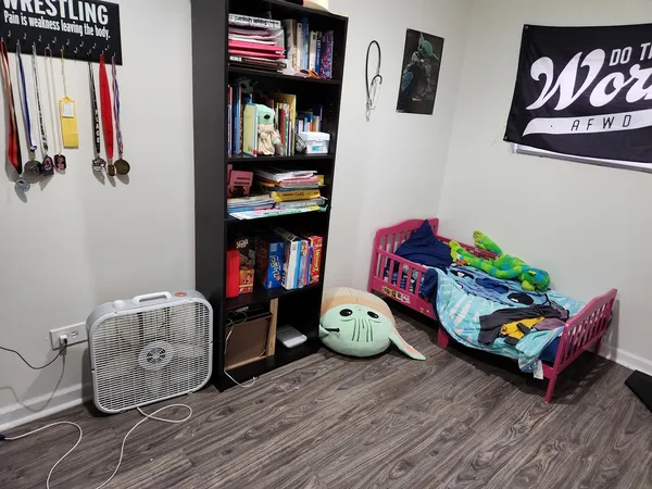 a room with wooden floor and book shelf