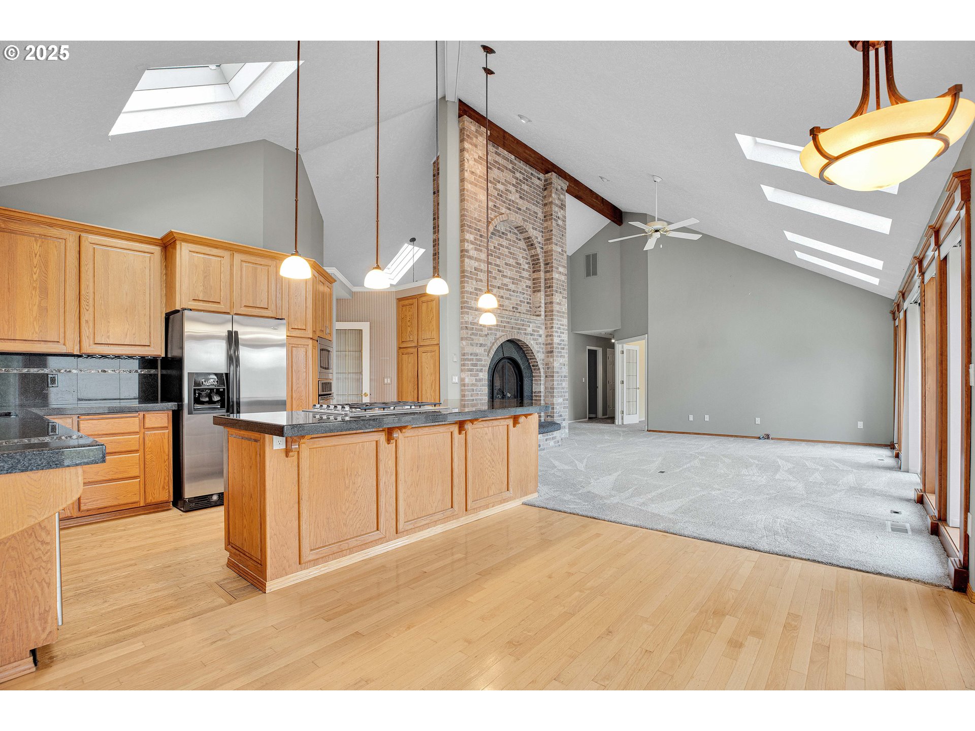 38651 Southeast Serban Road Sandy, OR 97055 - Photo 15 of 46 a open kitchen with stainless steel appliances kitchen island granite countertop a refrigerator and stove