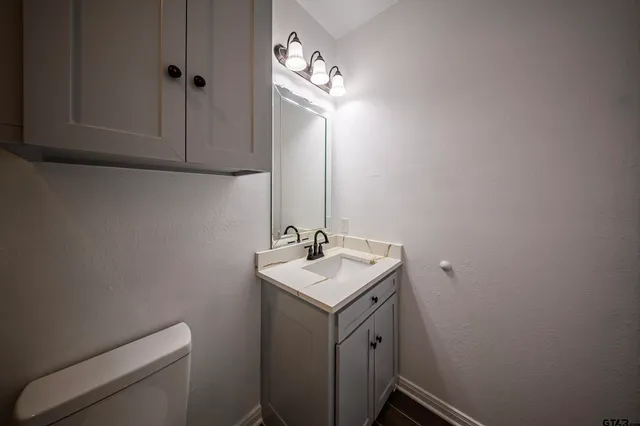 a bathroom with a toilet sink and mirror