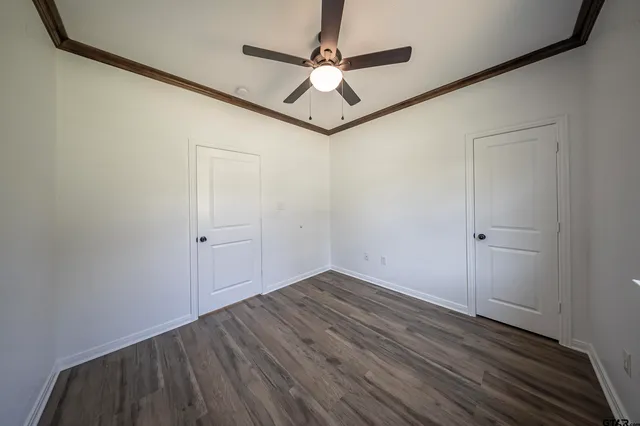 a view of a hallway with wooden floor and a ceiling fan