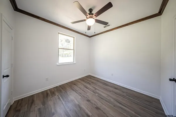 an empty room with a window and a ceiling fan