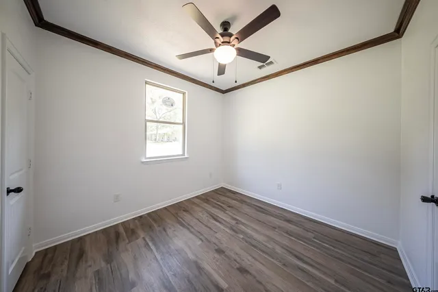 an empty room with a window and a ceiling fan