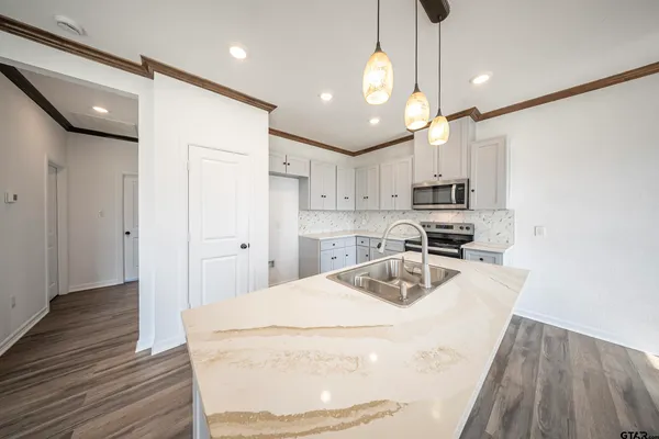 a kitchen with kitchen island a sink stainless steel appliances and cabinets