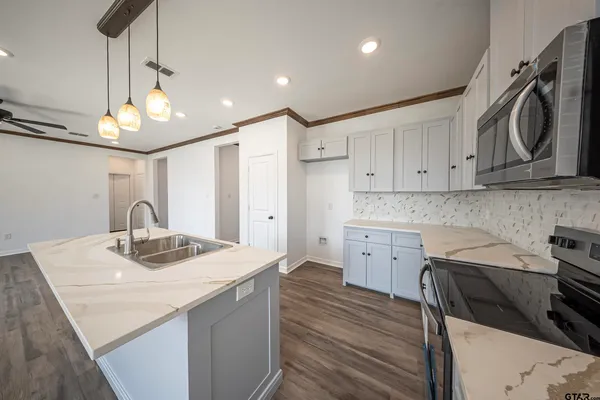 a kitchen with a sink a stove and cabinets